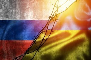 Russian and Ukrainian Flags divided by barbed wire