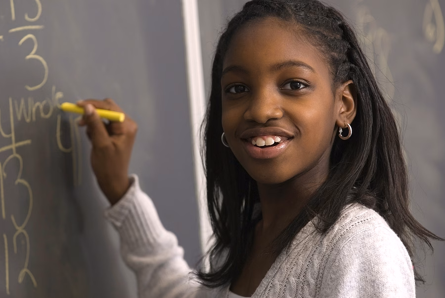 Student Doing Math On Chalk Board